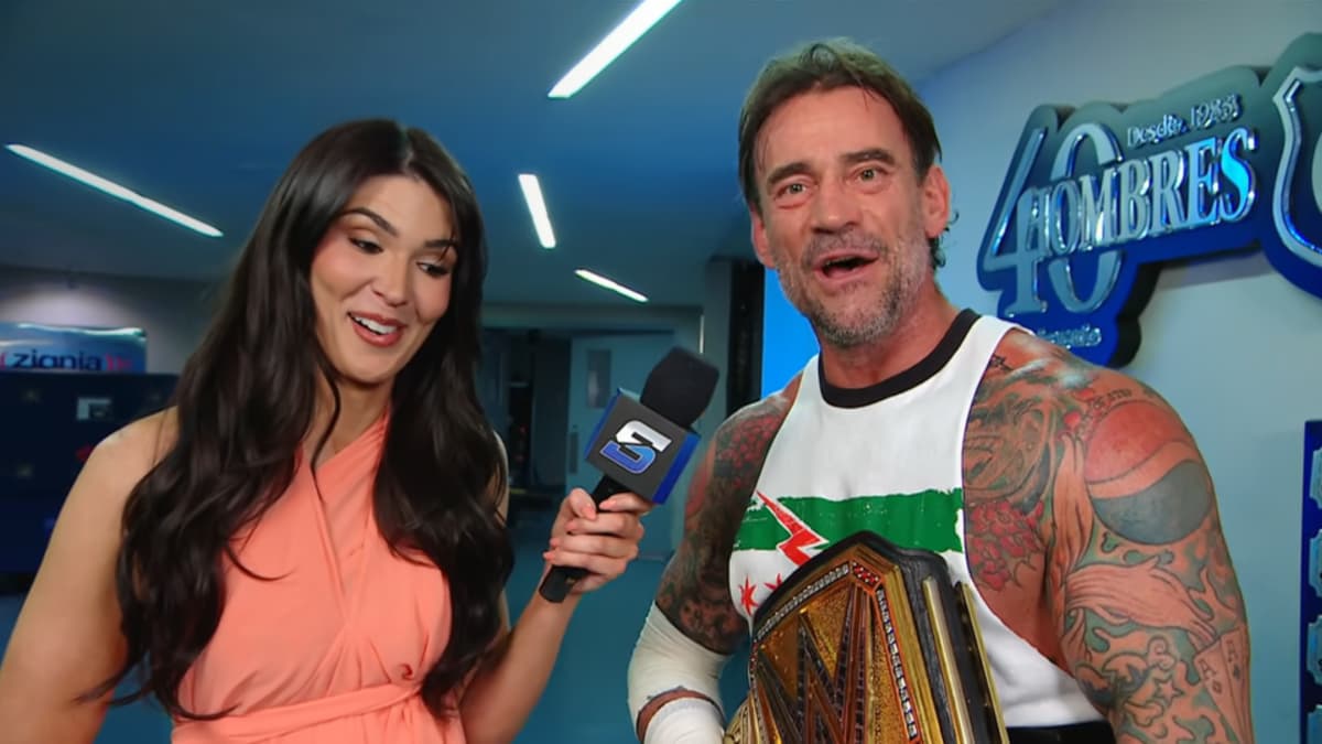 CM Punk grinning while Cathy Kelly looks surprised