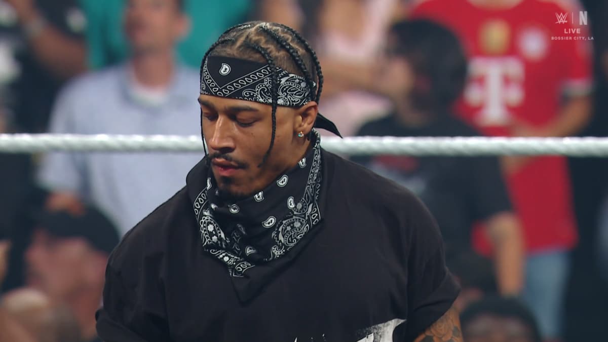 Carmelo Hayes in a black t-shirt and face mask bandana on WWE Raw