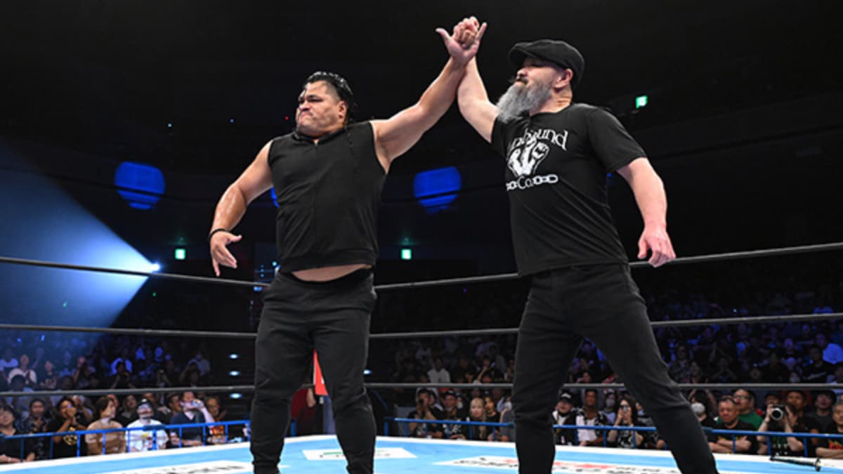 Jeff Cobb with his arm raised by Gedo