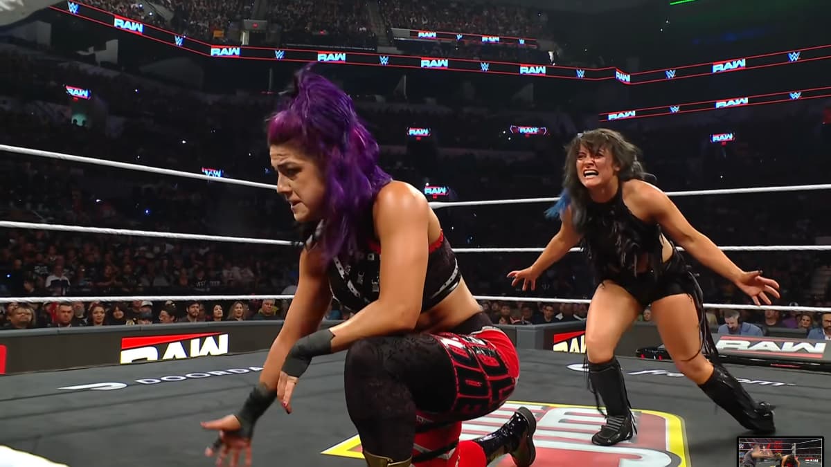 An angry Lyra Valkyria prepares to attack Bayley from behind in a WWE ring