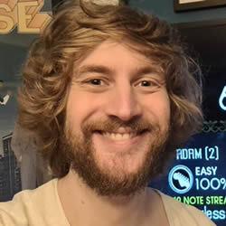 Adam Pacitti with long hair and smiling
