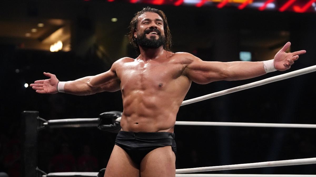 Andrade el Idolo with his arms outstretched while wearing black underwear