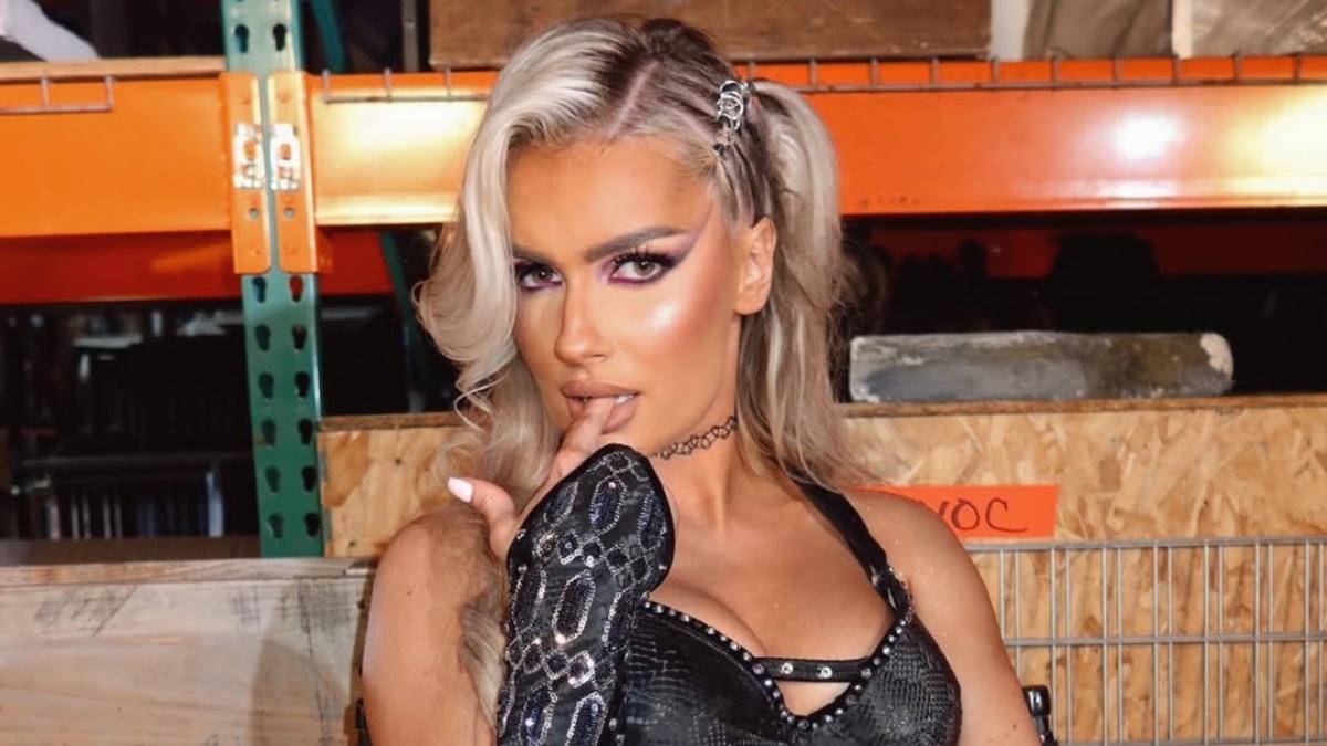 Blake Monroe sitting down and sticking her finger in her mouth 