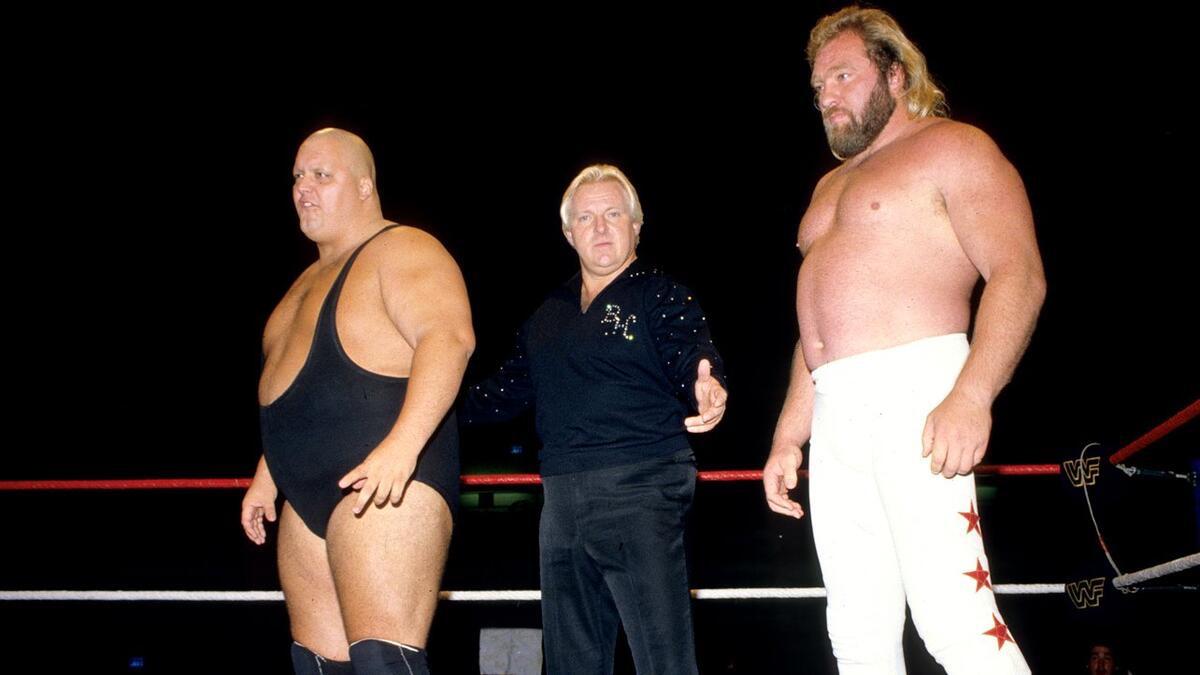 Bobby Heenan standing between King Kong Bundy on the left and Big John Studd on the right
