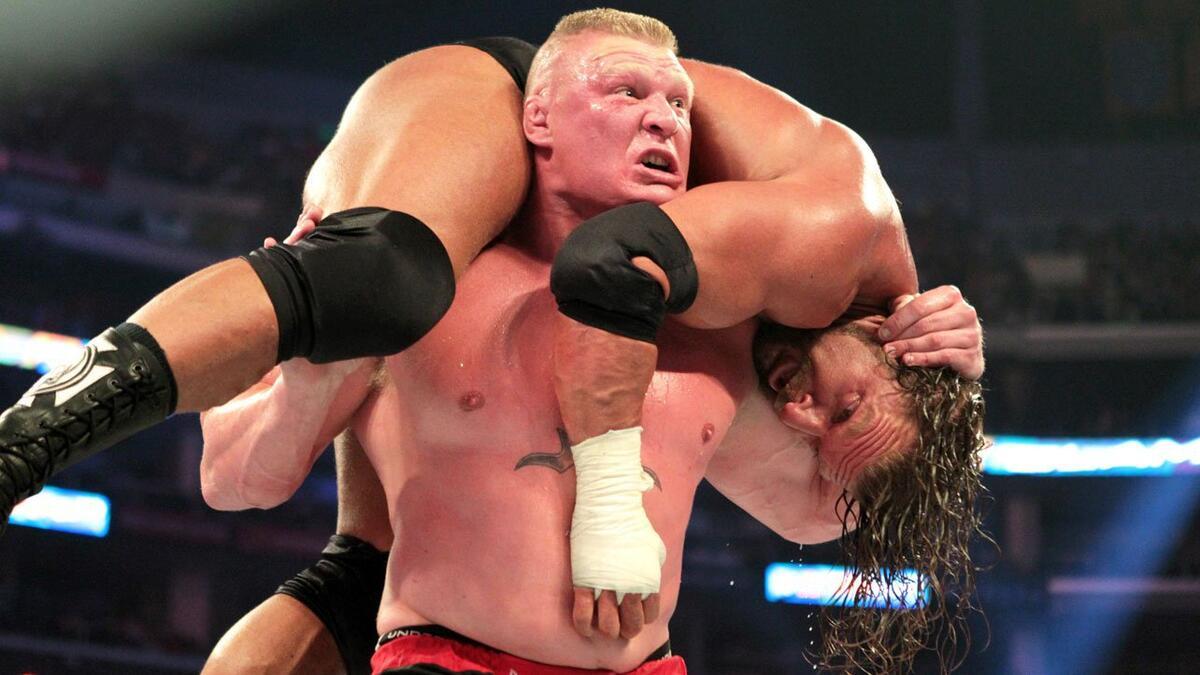 Brock Lesnar with Triple H on his shoulders for an F5 at WWE SummerSlam 2012