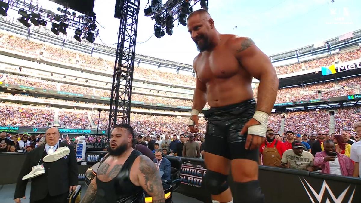 Bron Breakker stood on the announce table with Bronson Reed to his left