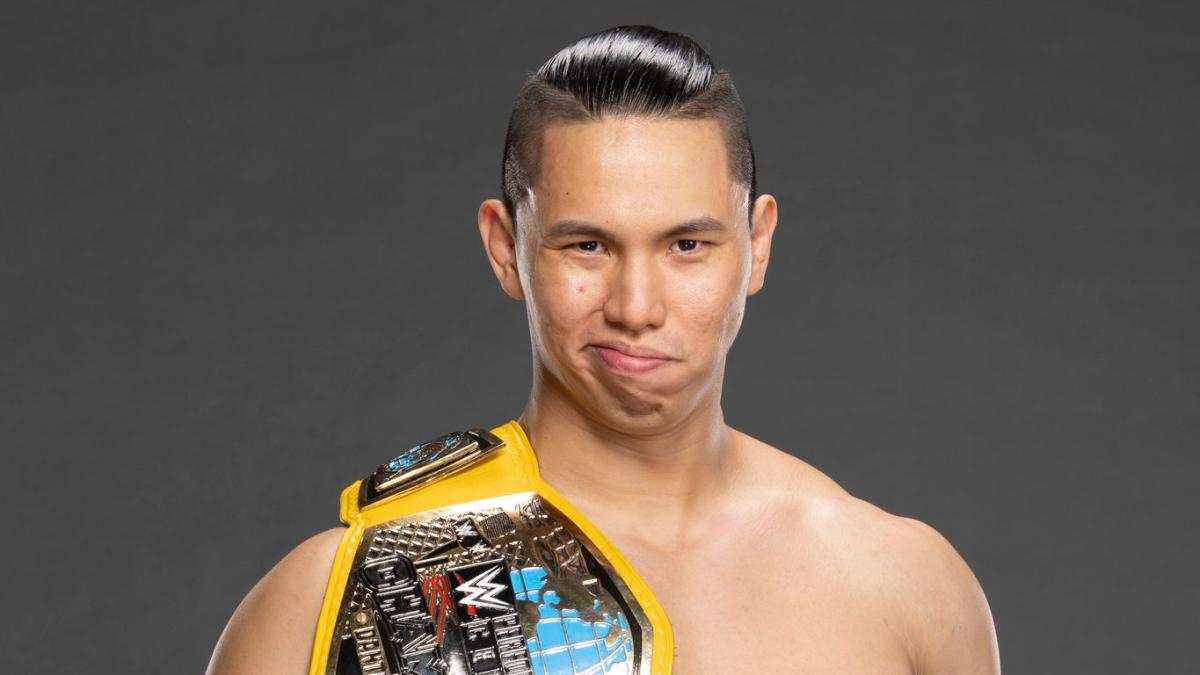 Dante Chen smiling with WWE Performance Center title over his shoulder