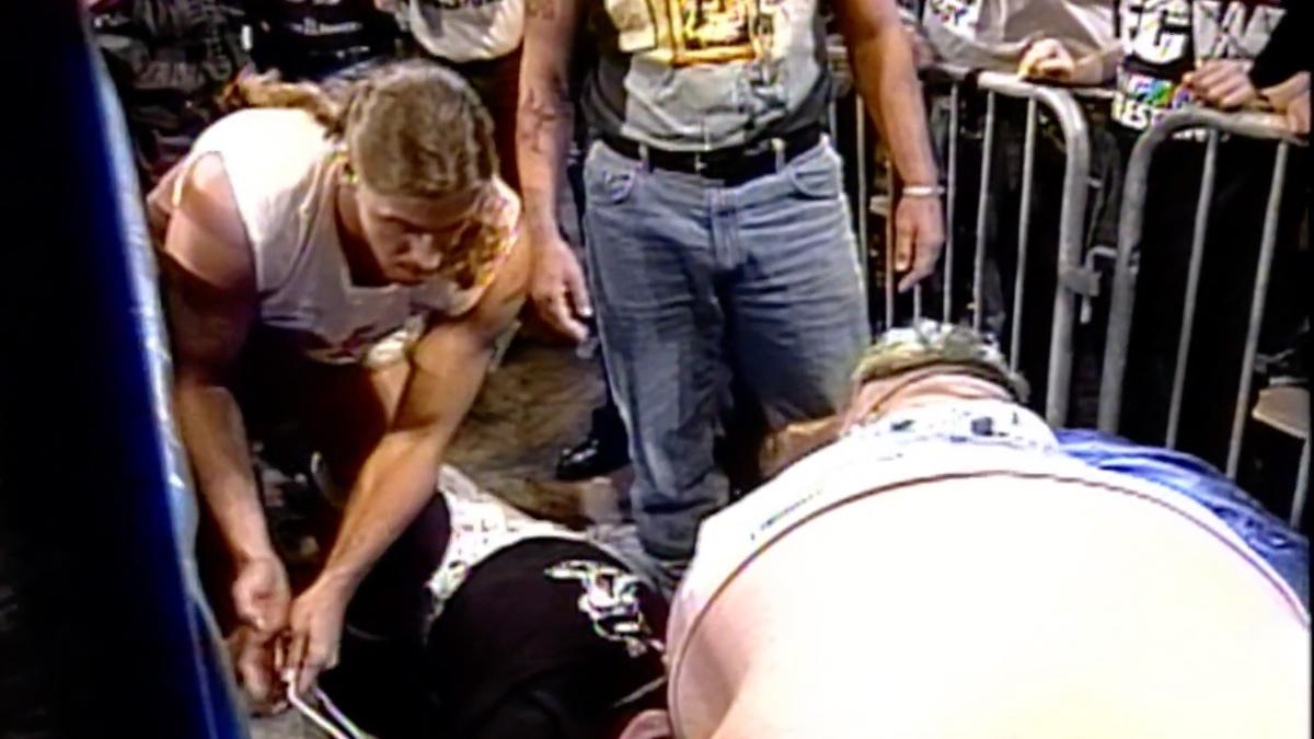 Sandman being strapped to the cross by Blue meanie and Stevie Richards