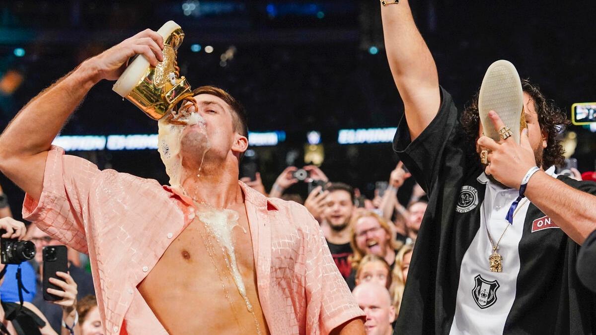Grayson Waller drinking a shoey with beer dripping down his chest