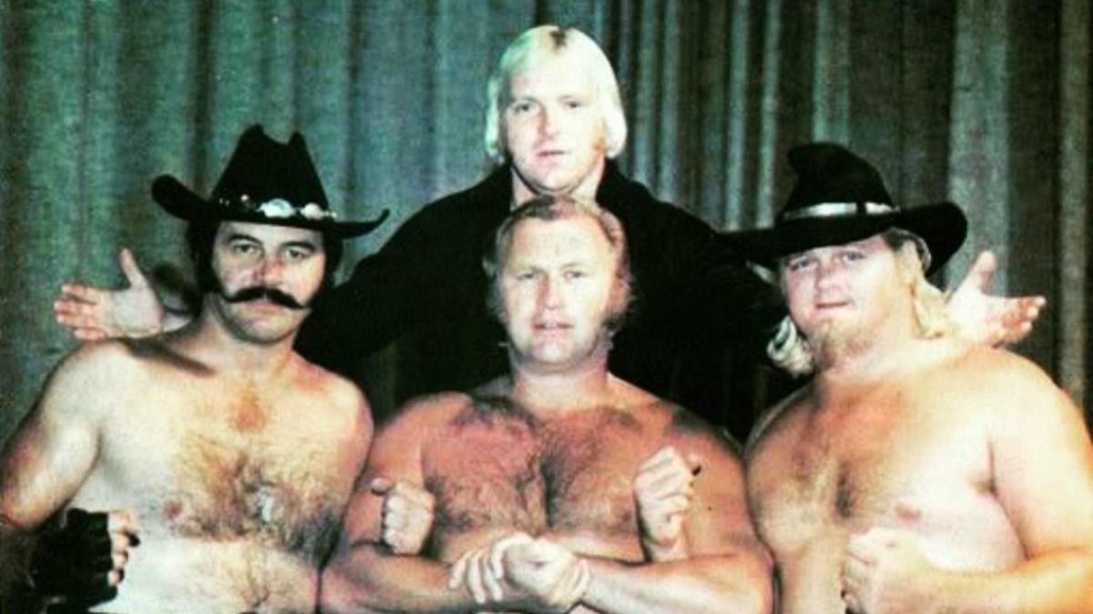 Blackjack Lanza, Nick Bockwinkel, and Bobby Duncum standing in a line with Bobby Heenan above them in the AWA