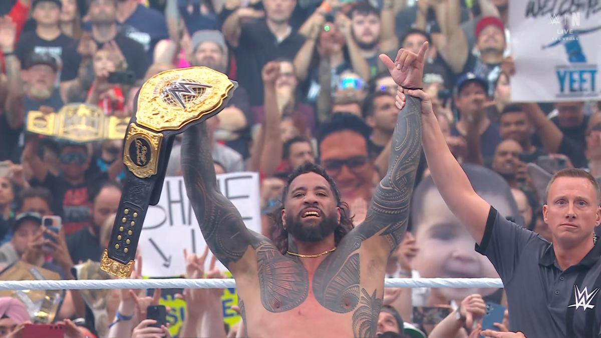 Jey Uso lifts the World heavyweight Championship as a referee raises his arm