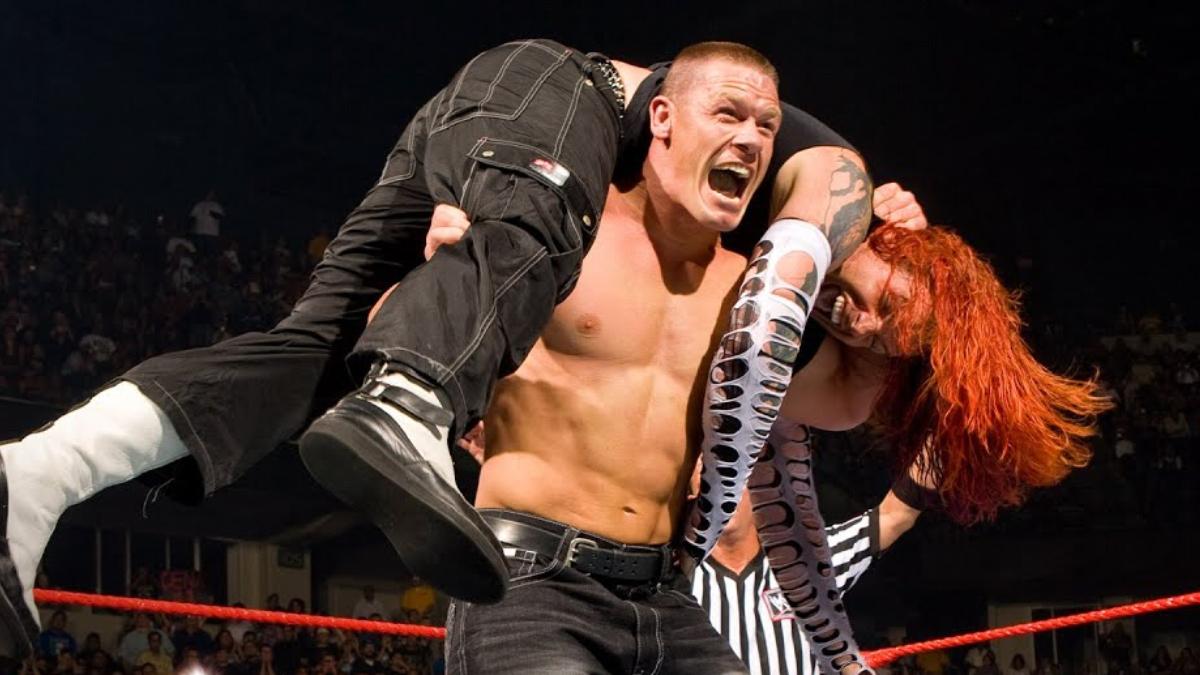 John Cena yelling with Jeff Hardy on his shoulders ready to deliver an Attitude Adjustment in a WWE ring