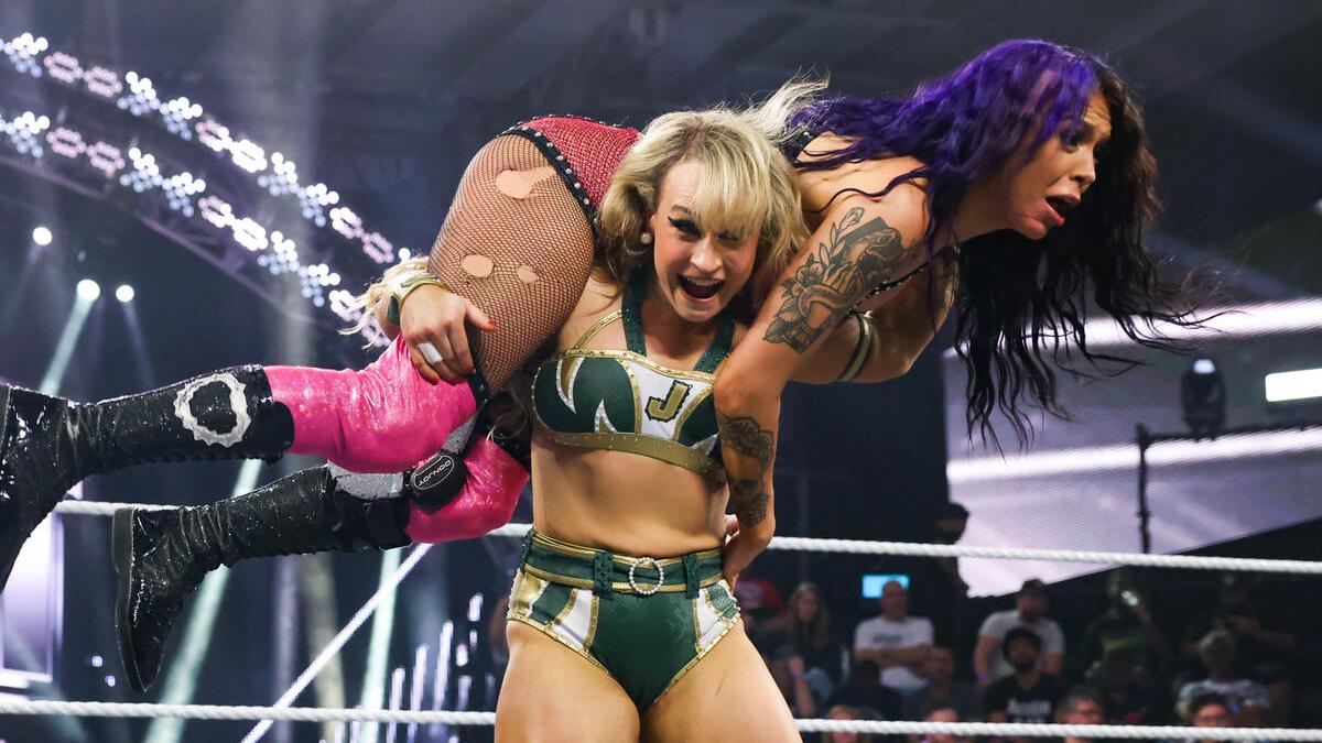 Jordynne Grace has a scared looking Cora Jade on her shoulders in preparation for a move inside a WWE NXT wrestling ring.