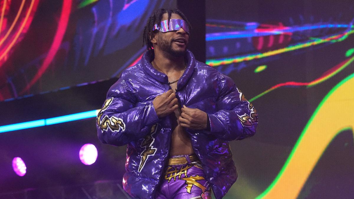 Kevin Knight in a purple jacket and sunglasses on his way to the ring