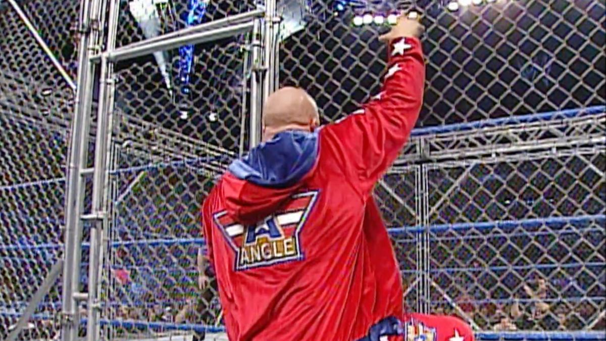 Kurt Angle climbing the cage on March 6, 2003 episode of SmackDown while wearing red Team Angle tracksuit