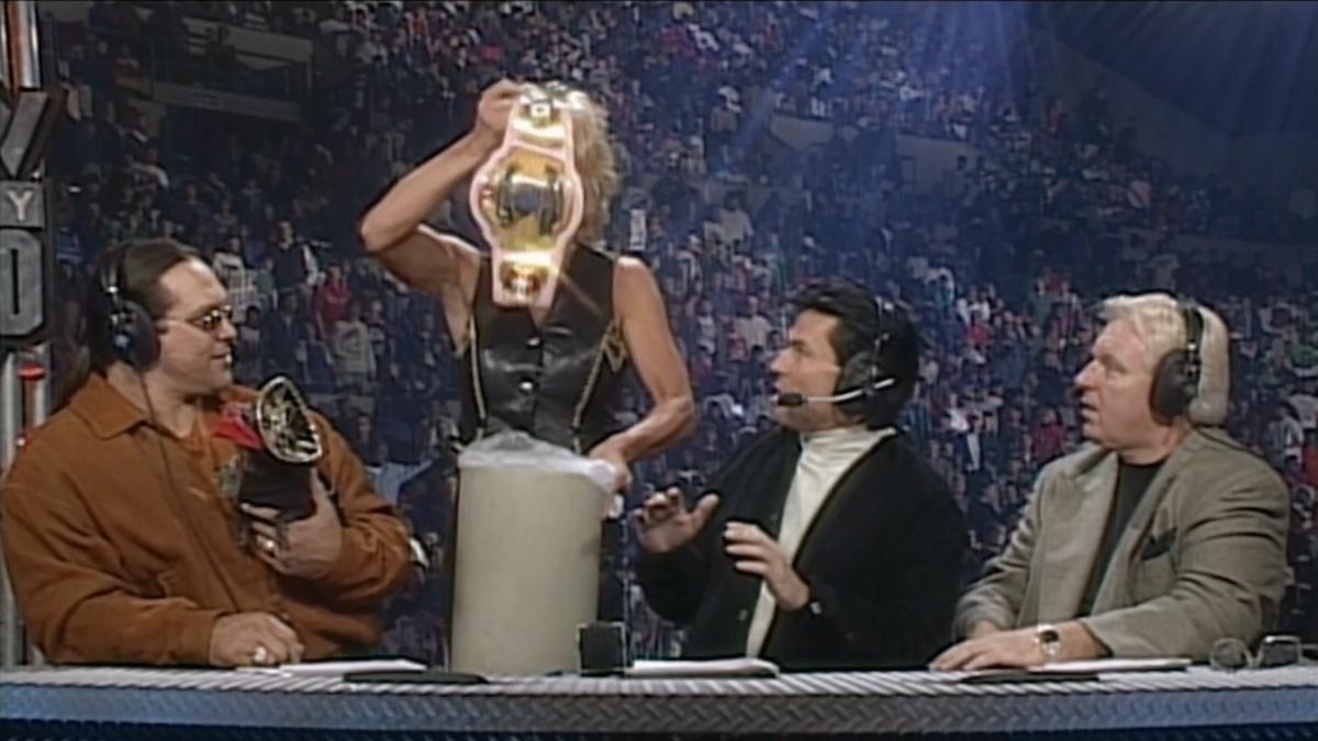 Madusa holding up the WWF Women's Title over a trash can