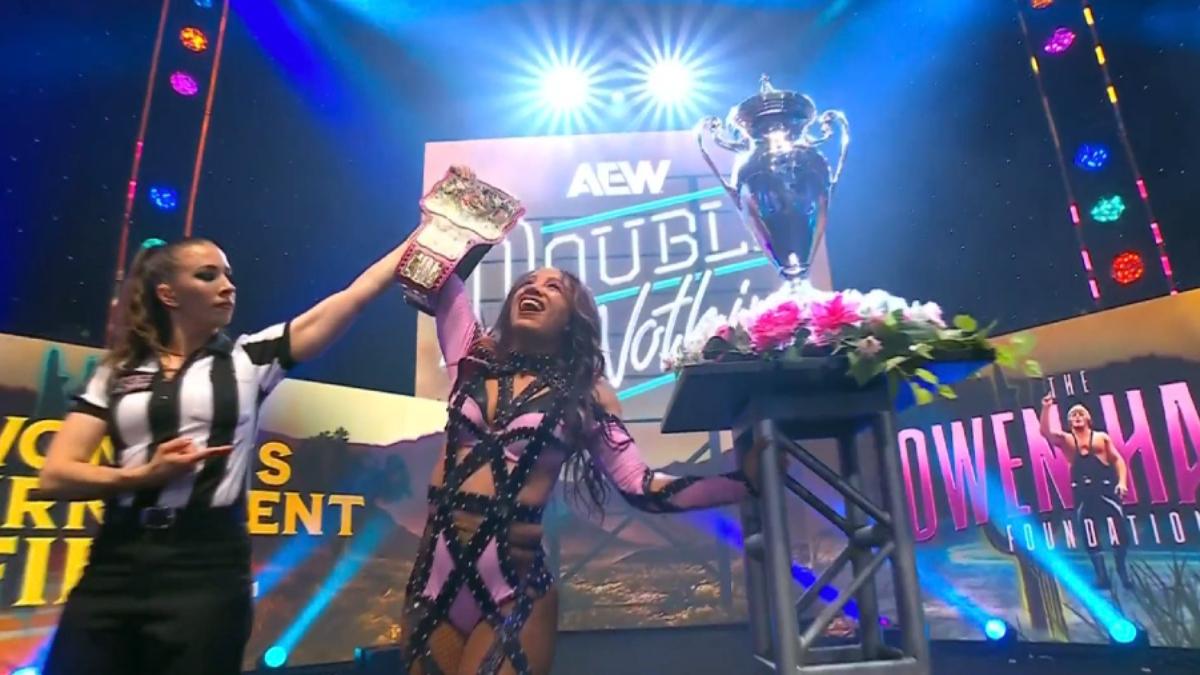 Mercedes Moné celebrates winning the Owen Hart Foundation tournament on an AEW entrance stage, the referee raising her hand in victory
