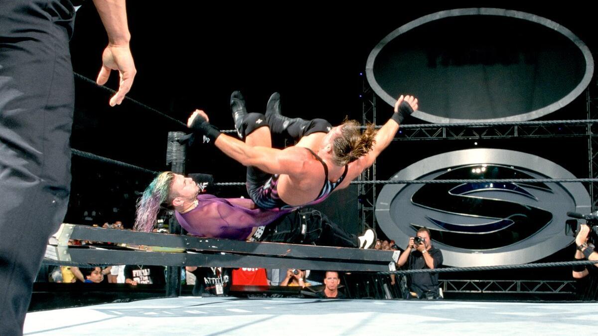 Rob Van Dam hitting a Senton to Jeff Hardy, who is lay across a ladder, at WWE SummerSlam 2001