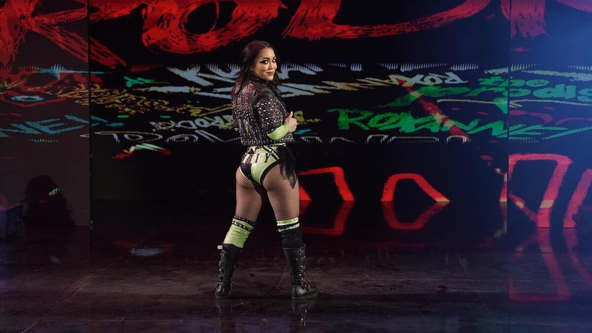 Roxanne Perez turning around during her WWE Raw entrance in green gear and a leather jacket 
