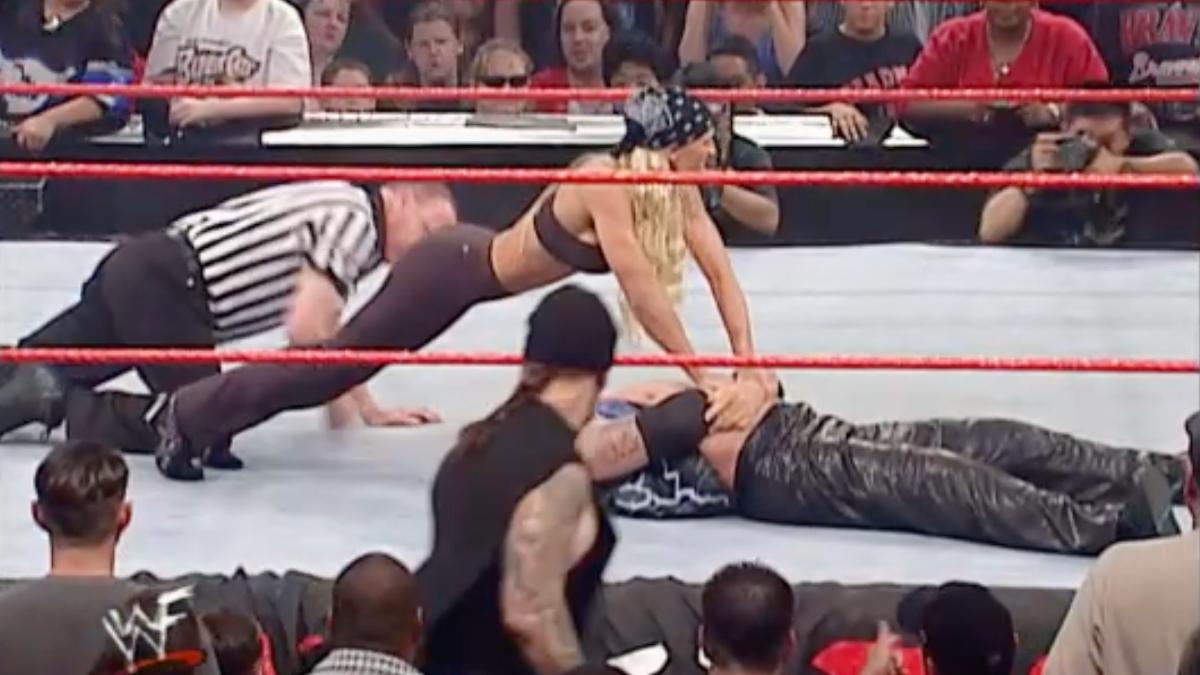 Sara pinning Diamond Dallas Page as The Undertaker watches on during WWE Raw