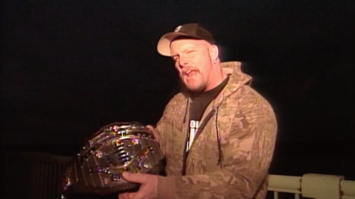 Steve Austin wearing a camouflage jacket holding the WWE Intercontinental Title