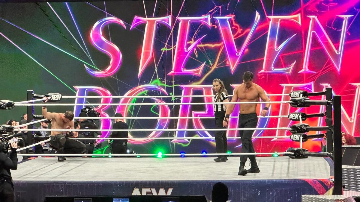 Steven Borden stood in the ring in black pants with 'Steven Borden' written in giant letters on the video screen