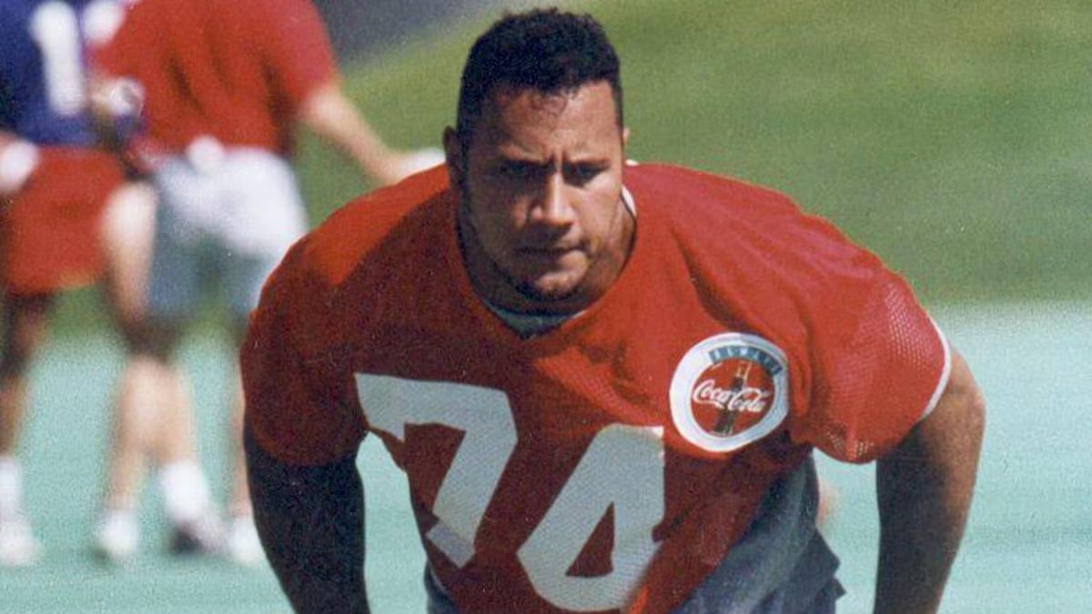 The Rock in a red shirt training at the Calgary Stampeders