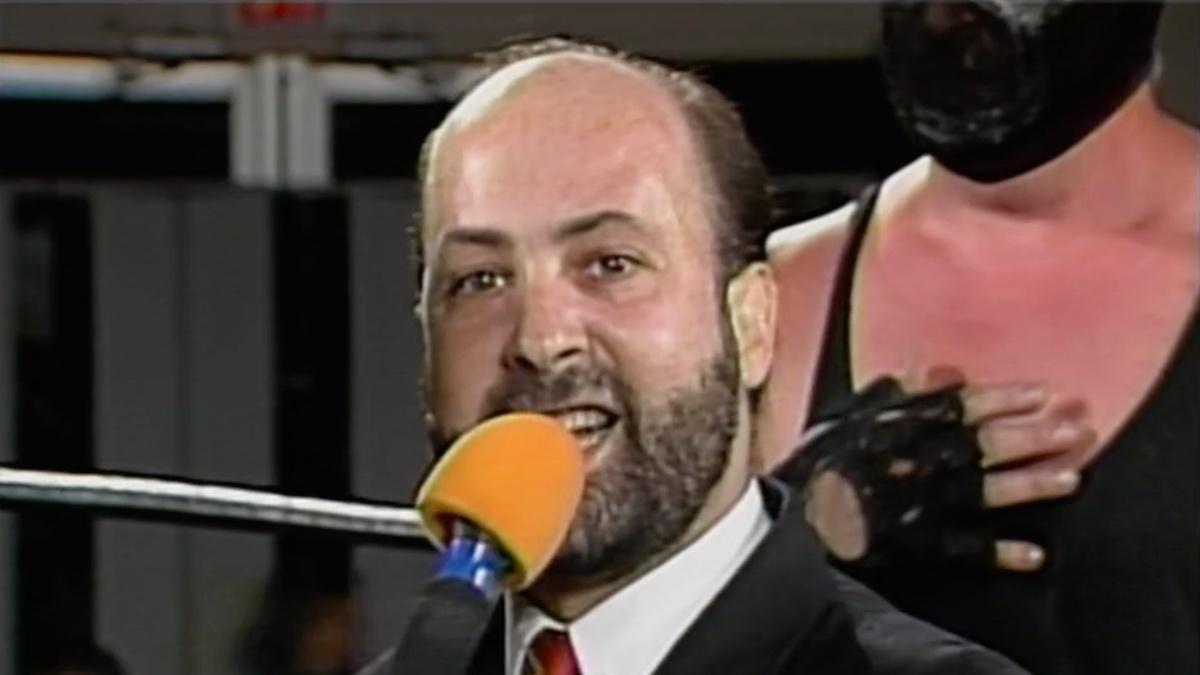 Tod Gordon holding a yellow microphone in Eastern Championship Wrestling