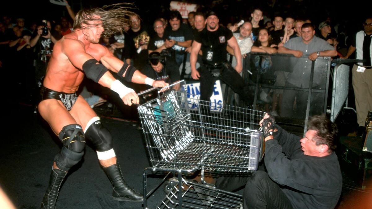 Triple H rams a shopping trolley/cart into a downed Vince McMahon in front of an audience.
