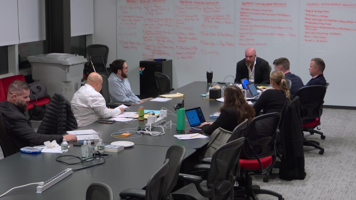 Triple H speaking to the WWE creative team in a meeting room