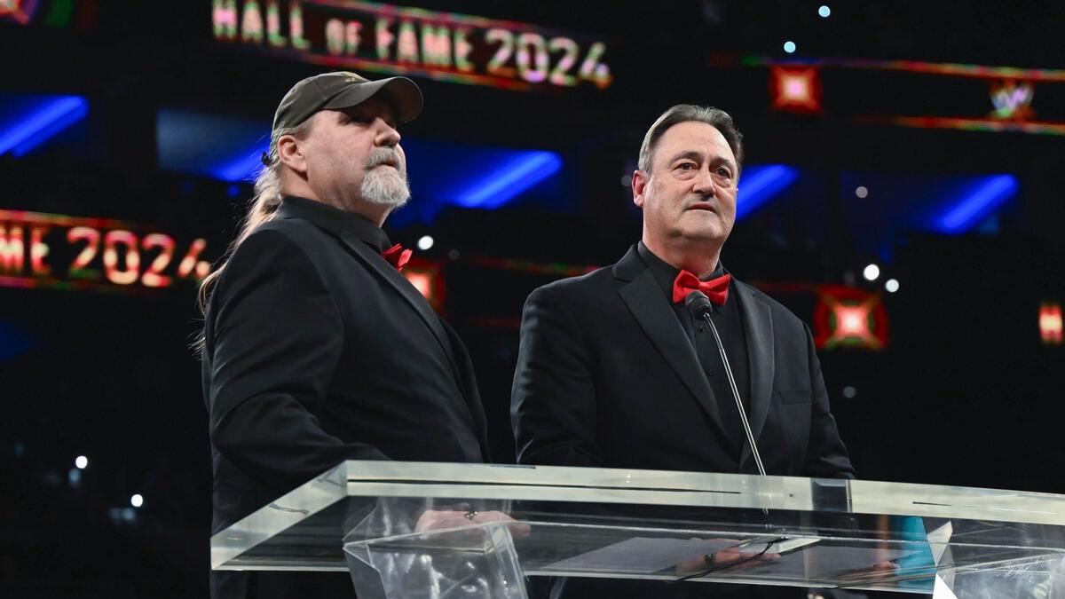 Barry Windham and Mike Rotunda standing at a podium during WWE Hall of Fame induction 