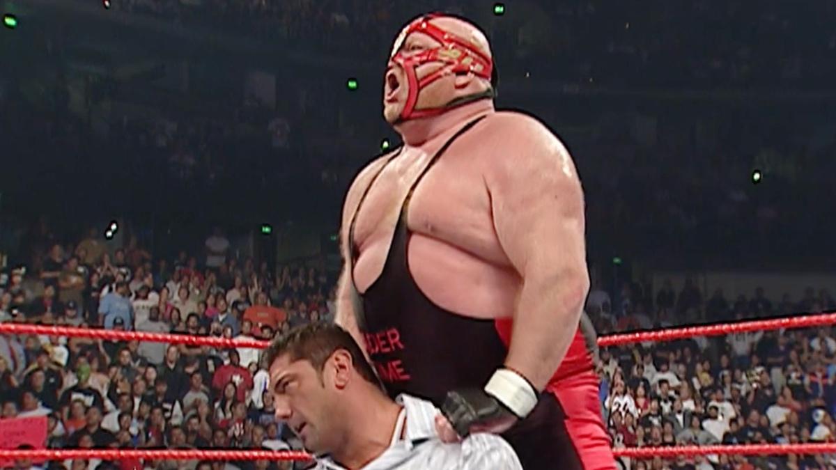 Vader celebrating as Batista sits down during a beatdown on WWE Raw