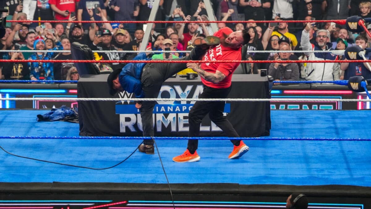 Shawn Michaels kicking Kevin Owens in a WWE ring