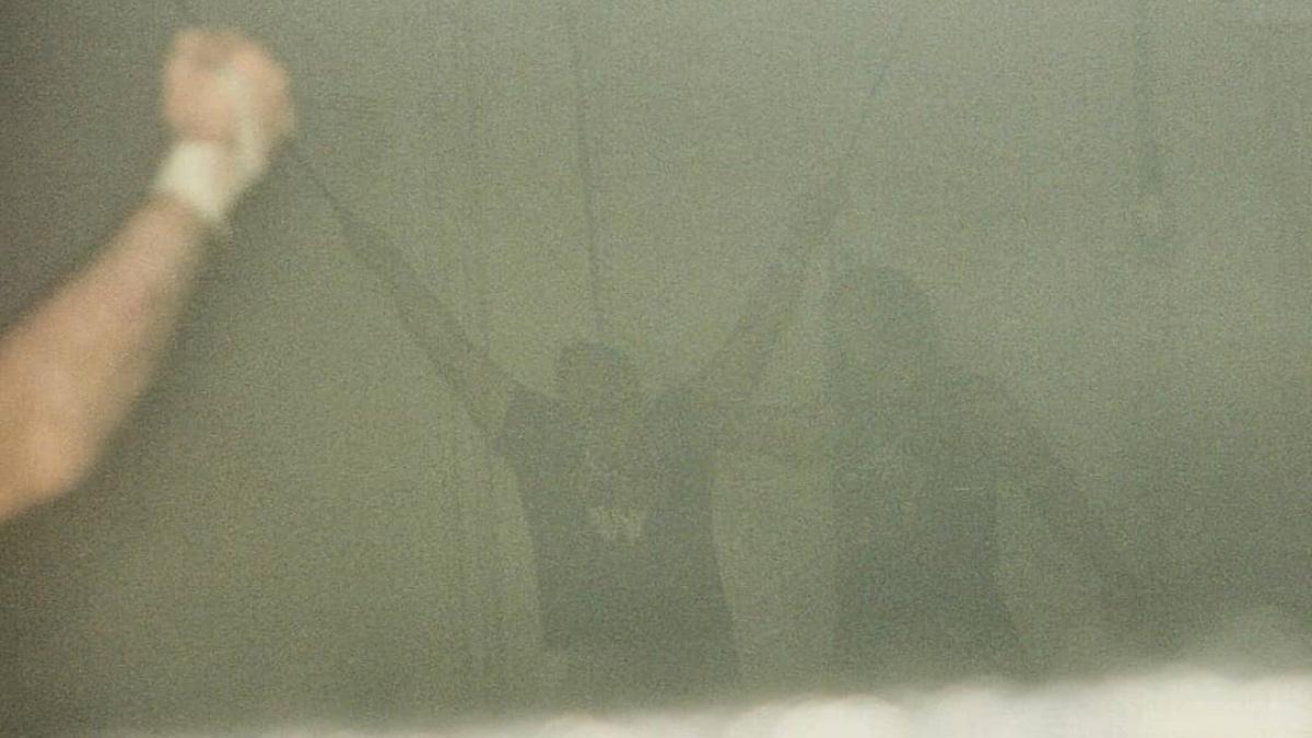 Raven stood next to Tommy Dreamer in a mock cruxifixction as the air is full or smoke