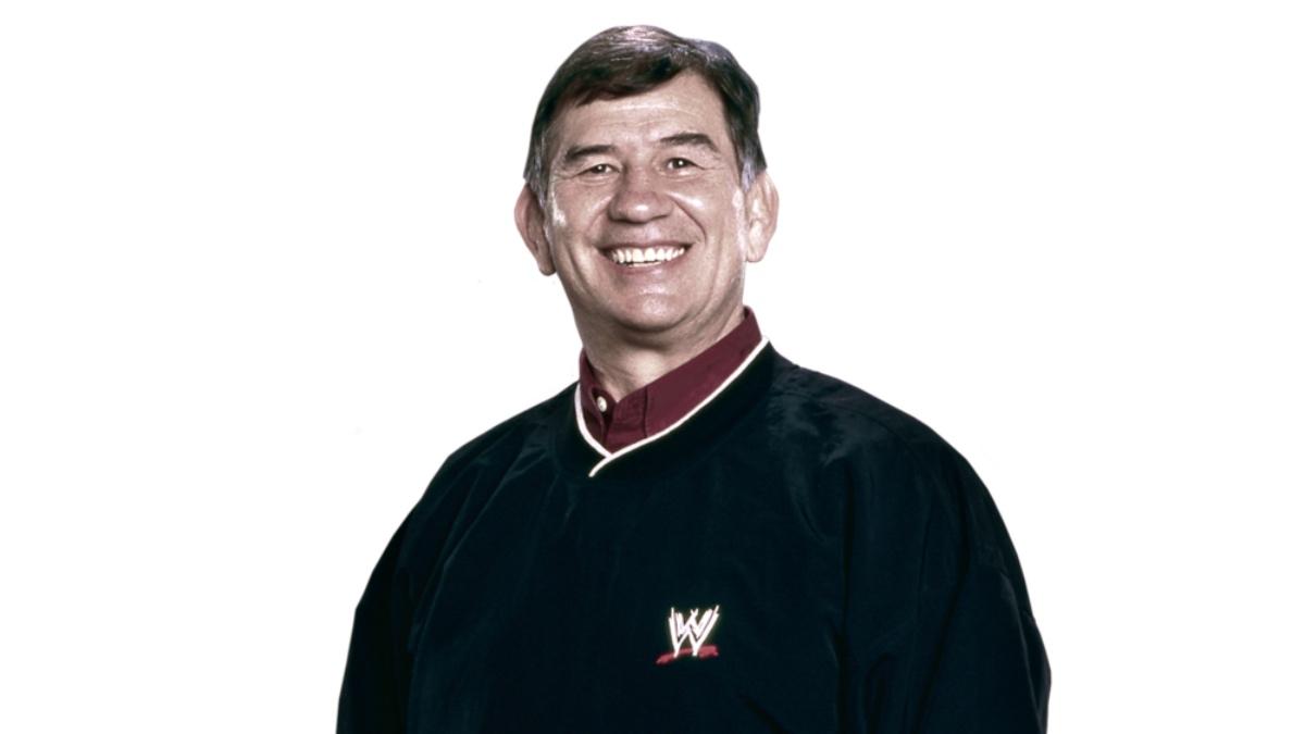 Gerald Brisco on a white background smiling in a WWE black sweater