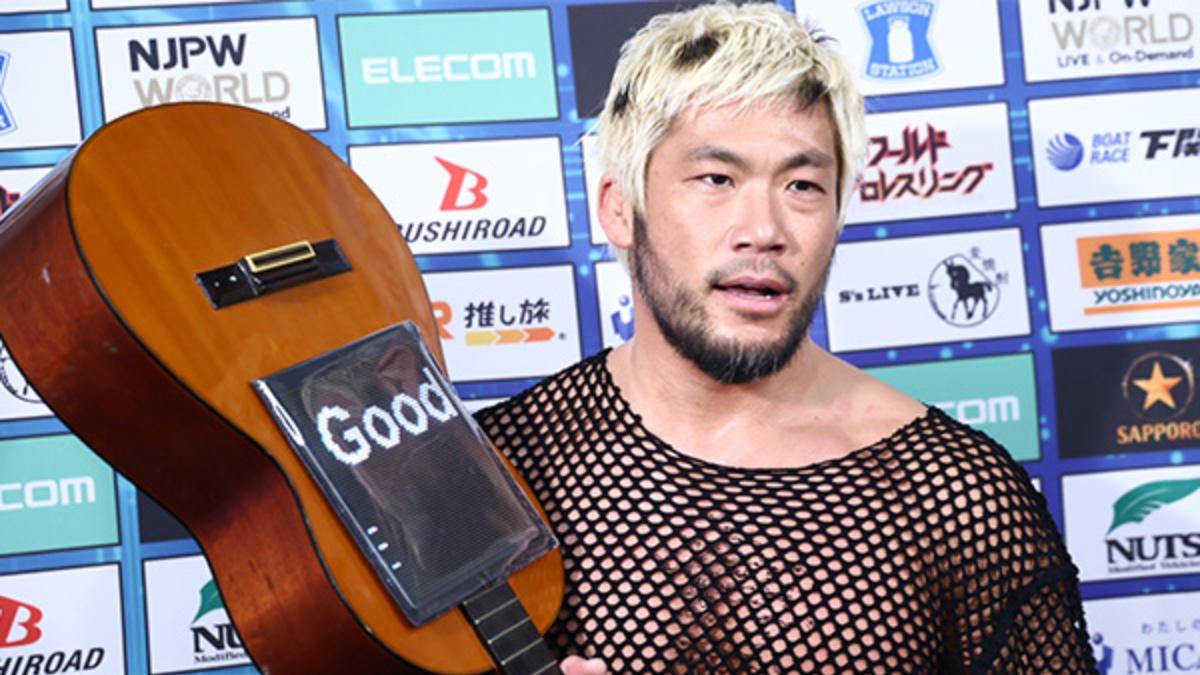 SANADA backstage at NJPW New Year Dash 2026 holding a guitar and wearing a fishnet shirt